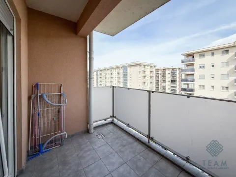 Natkriveni balkon sa pločicama i pogledom na zgrade u okruženju. - image 7