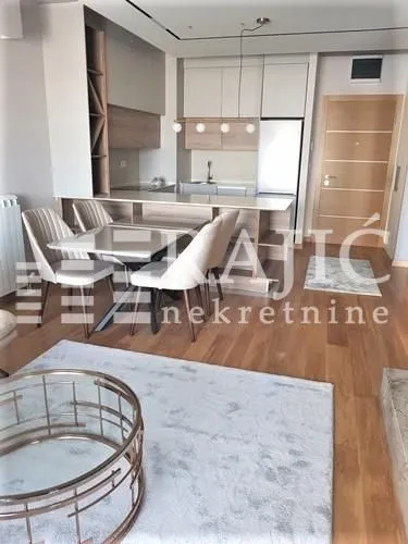 Living room with dining area and kitchen in light tones.