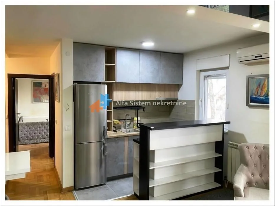 Kitchen with cabinetry and a bar counter connected to the living room.