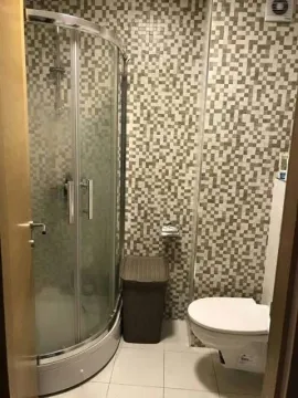 Compact bathroom with a shower cabin and toilet. - image 7