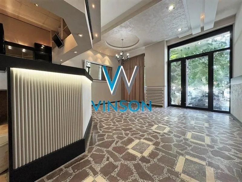 Spacious living room with a bar counter and large glass surfaces.