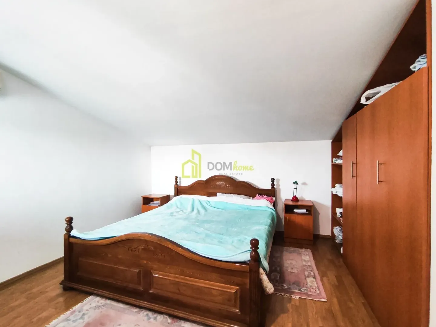 Bedroom with a large wooden bed and built-in wardrobe.
