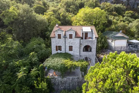 Pogled iz vazduha na kamenu kuću okruženu zelenilom. - image 21