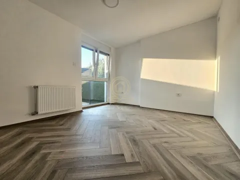 Prazna svetla soba sa parketom i radijatorom. - image 3