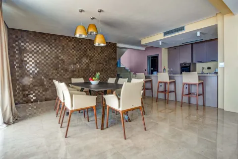 Svijetla trpezarija sa modernim stolom i kuhinjskim šankom u pozadini. - image 11