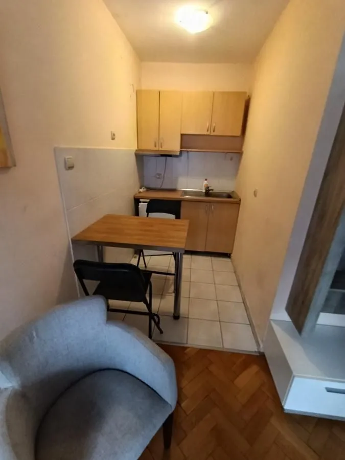 Smaller kitchen with wooden units and a dining table.