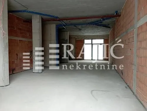 Unfurnished commercial space in grey phase with brick walls.