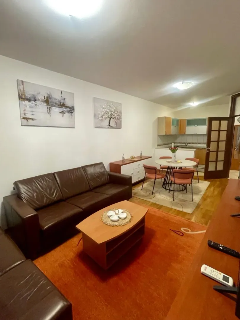 Living room with sofa and dining area in an open-plan space.