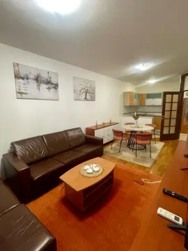 Living room with sofa and dining area in an open-plan space. - image 2