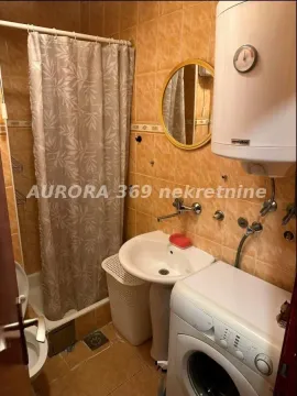Kupatilo obloženo keramičkim pločicama sa tuš kabinom, umivaonikom i veš mašinom. - image 8