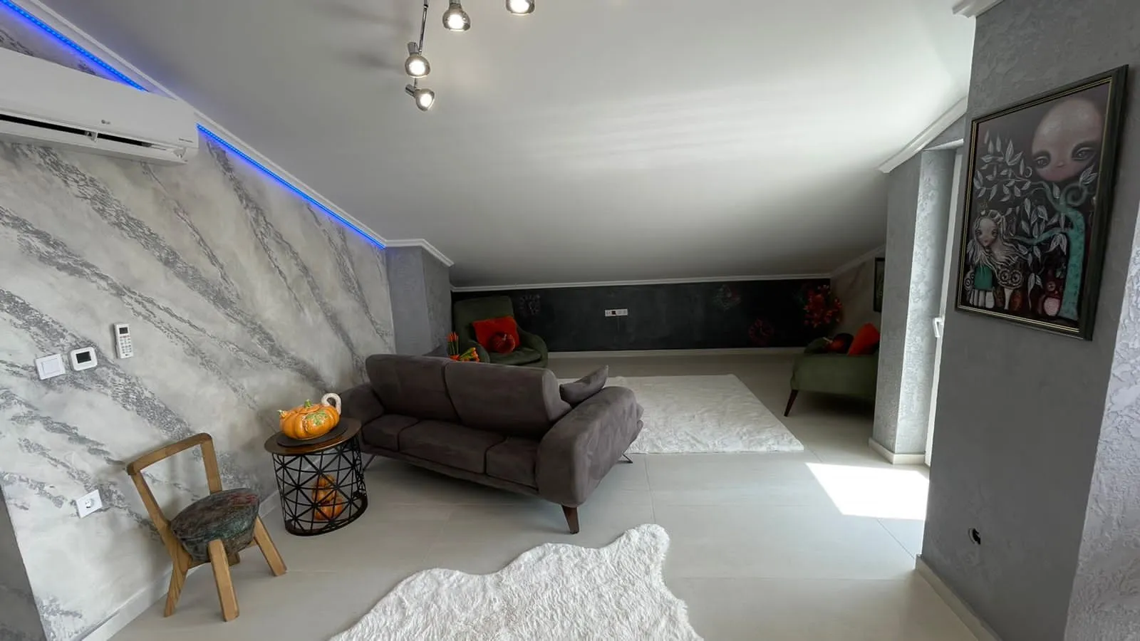 Living room with a sofa set and decorative lighting under a sloped ceiling.