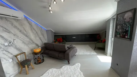Living room with a sofa set and decorative lighting under a sloped ceiling. - image 10