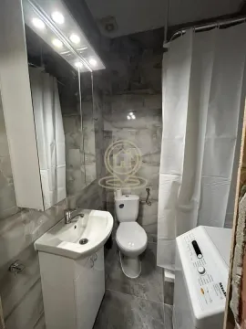 Compact bathroom with a sink, toilet, shower cabin, and washing machine. - image 8