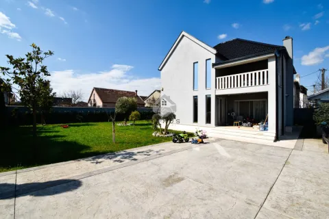 View of the courtyard and house facade with a manicured lawn and parking area. - image 2