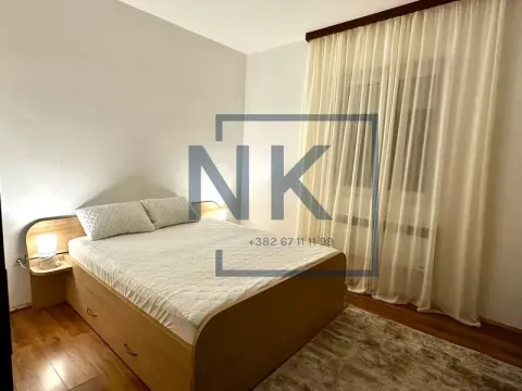 Furnished bedroom with a double bed, bedside tables, and a window with curtains. - image 5