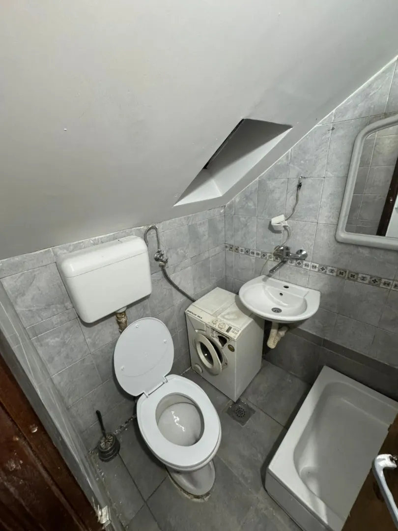 Small bathroom with sanitary fixtures and a washing machine.