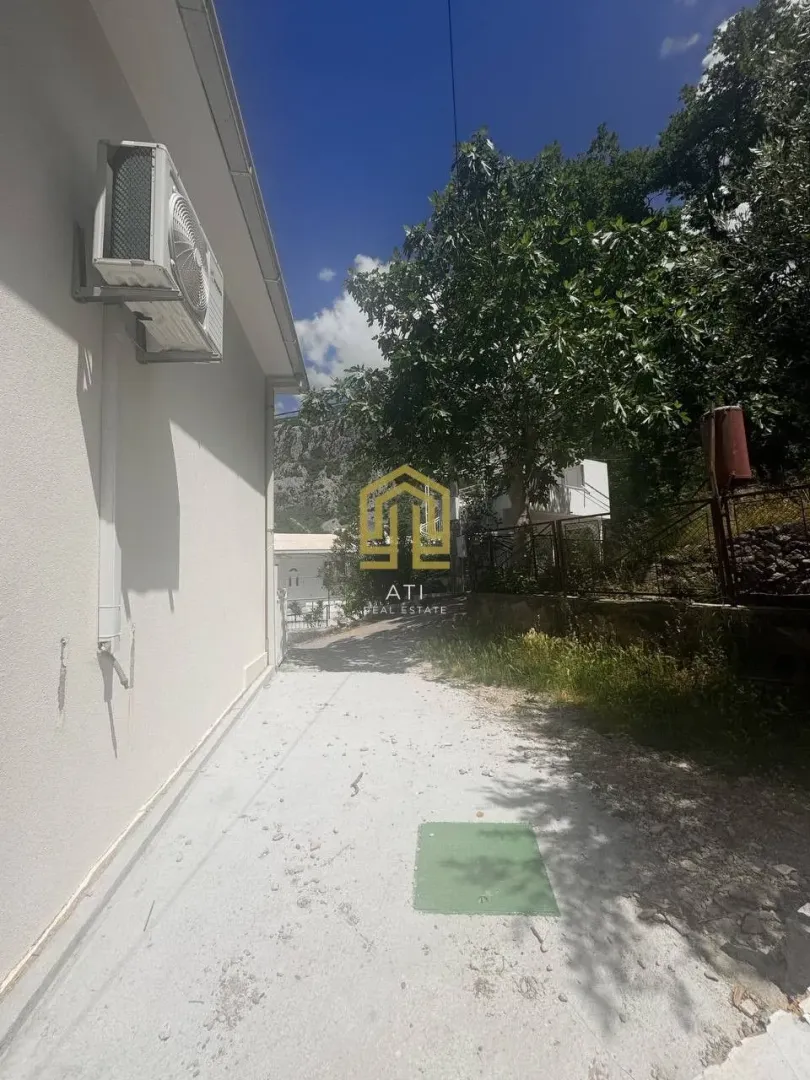 Bočna strana kuće sa dvorištem i zelenilom.