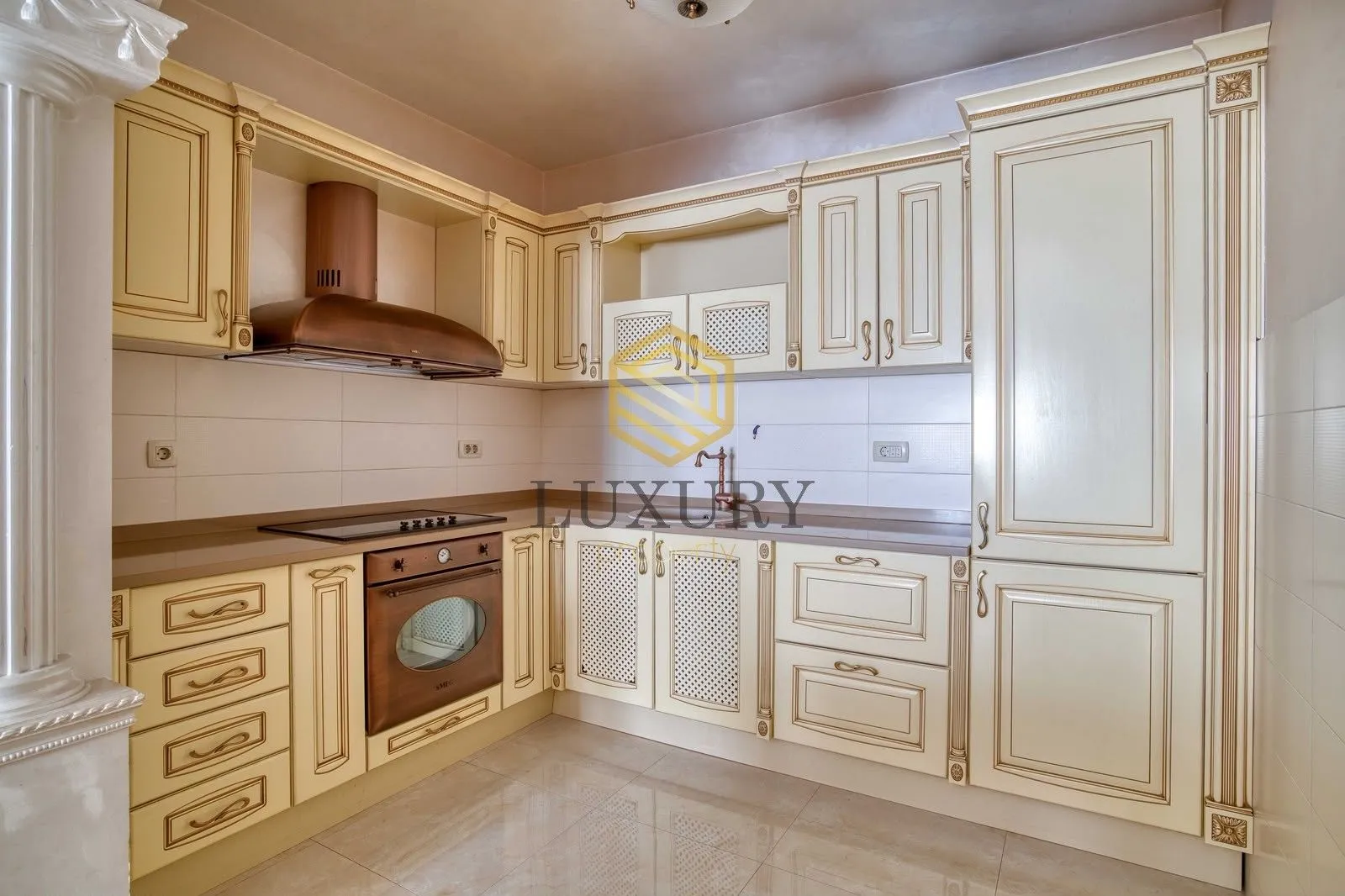 A classically styled kitchen with beige cabinetry and built-in appliances.