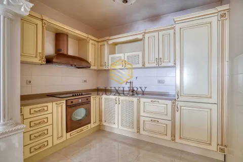 A classically styled kitchen with beige cabinetry and built-in appliances. - image 9