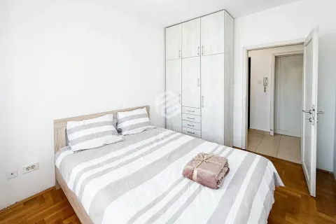 Spavaća soba sa bračnim krevetom, bijelim ormarom i drvenim podom. - image 4
