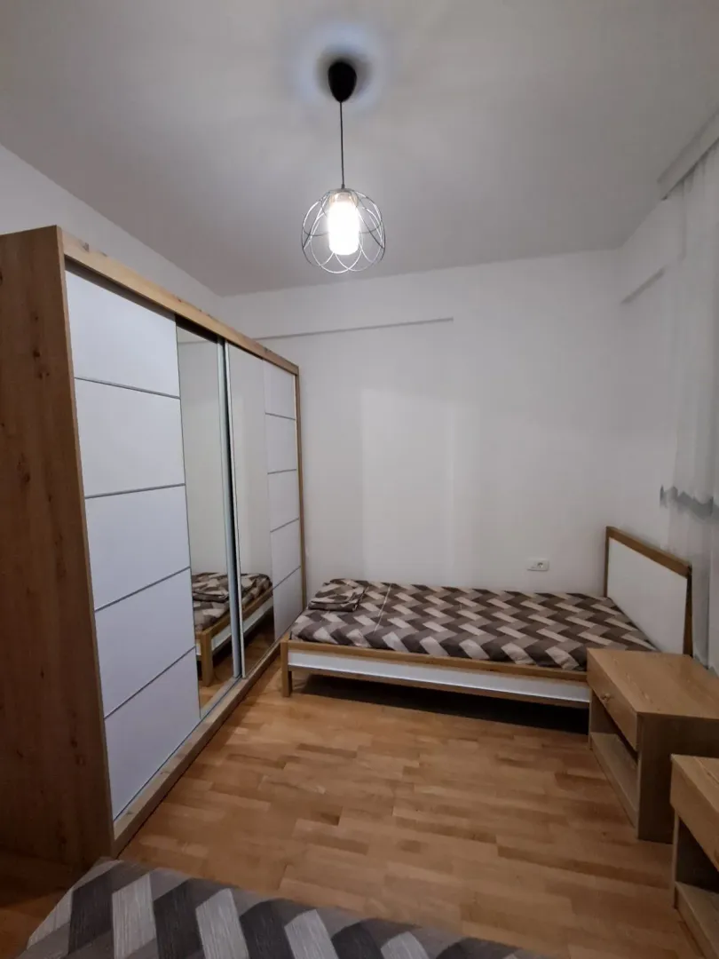 A bedroom with a bed and a large wardrobe.