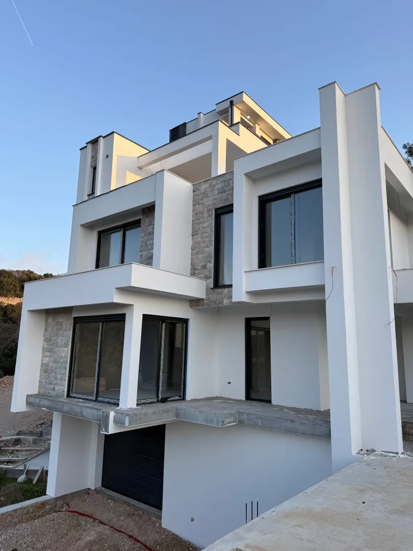 Spoljašnji izgled moderne višespratne kuće sa terasama i velikim prozorima.