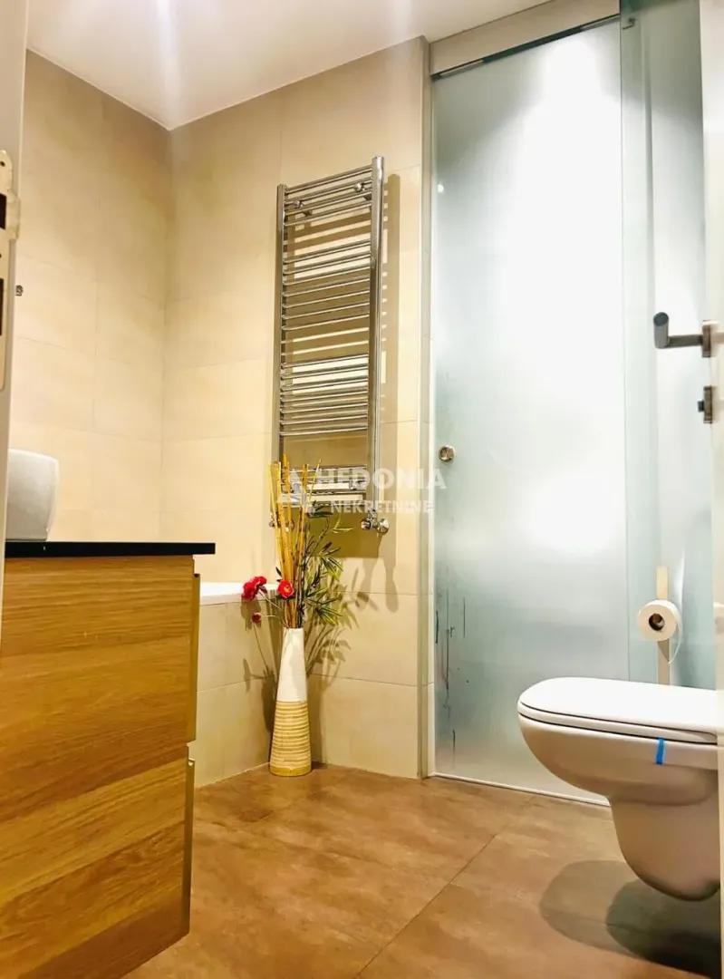 Moderno kupatilo sa tuš kabinom, WC šoljom i umivaonikom.