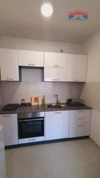 Small kitchen with white cabinetry, sink, and built-in oven. - image 4