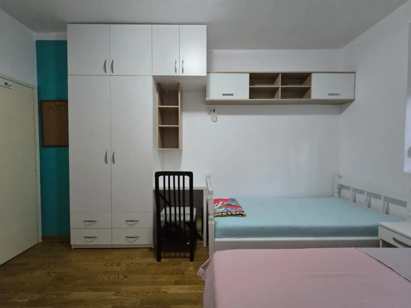 Children's bedroom with beds, a large wardrobe, and a desk.