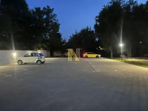 Osvetljeni parking prostor sa parkiranim automobilima noću. - image 14