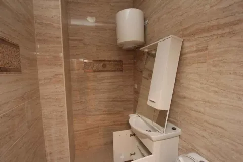 Kupatilo sa svijetlim pločicama, lavaboom i bojlerom. - image 18