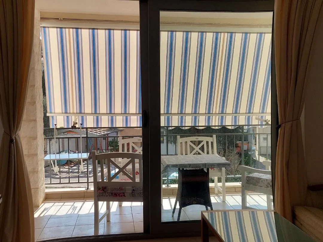 View of a covered terrace with seating furniture through the balcony door.
