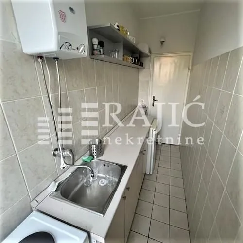 Small narrow kitchen with a sink and cabinets.