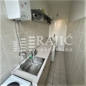 Small narrow kitchen with a sink and cabinets. - image 3
