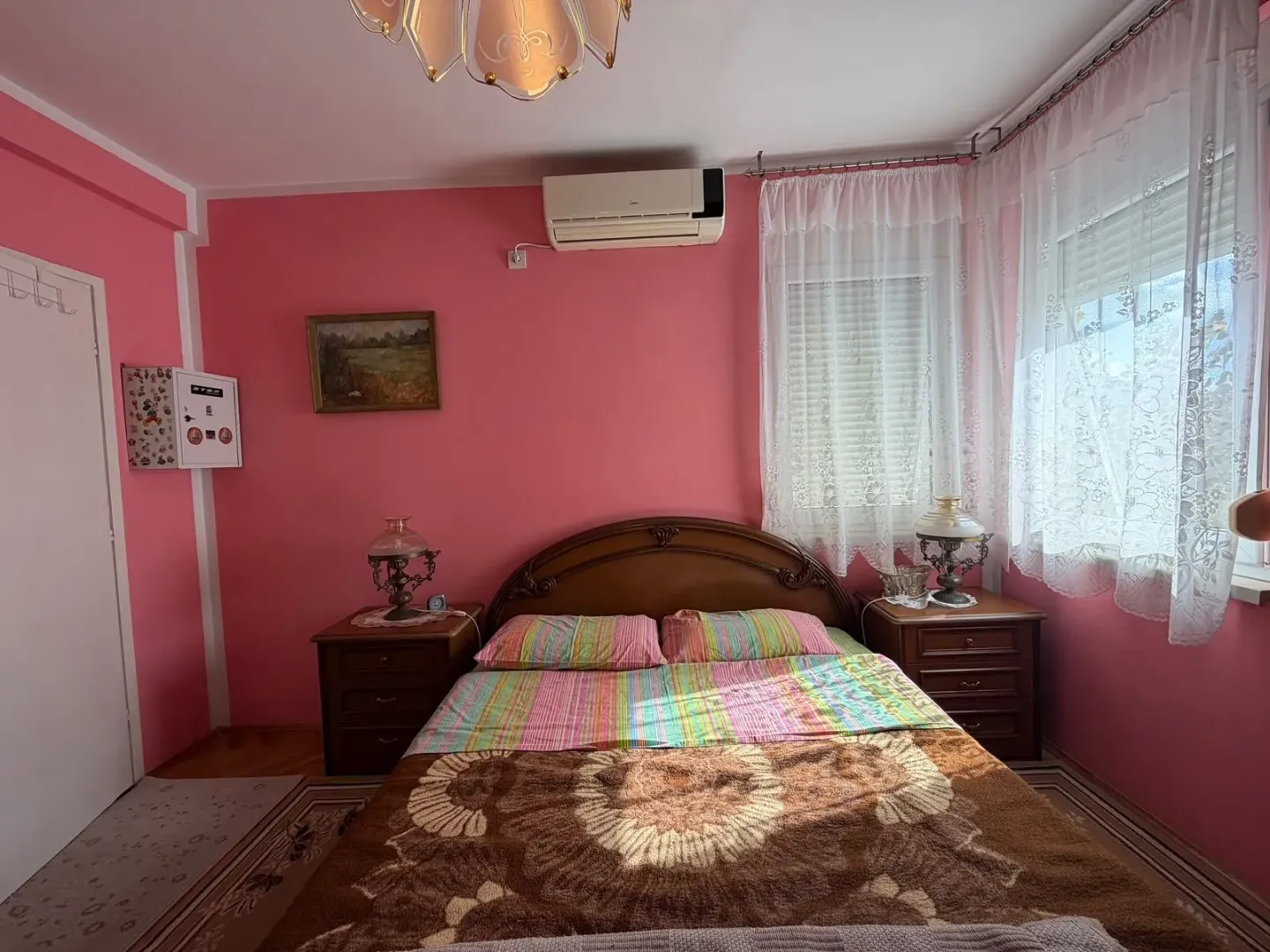 Bedroom with a double bed, nightstands and pink walls.
