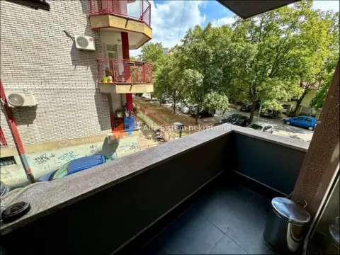 Small tiled balcony with a view of the street and greenery. - image 2