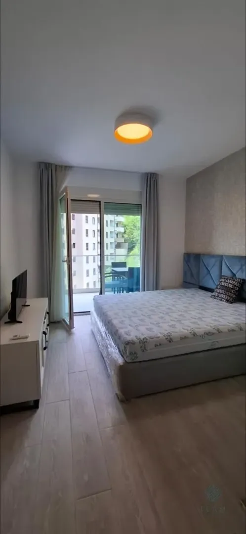 Namještena spavaća soba sa bračnim krevetom i izlazom na terasu.