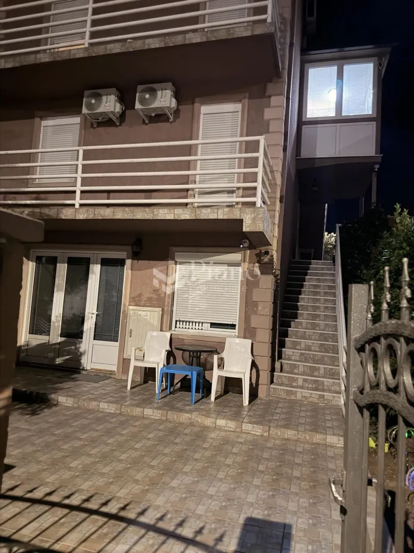 Exterior of the house at night with a yard and stairs.