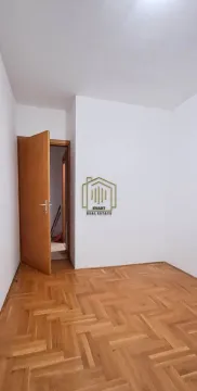 Prazna soba sa parketom i otvorenim drvenim vratima. - image 2