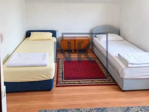 Spavaća soba sa dva odvojena kreveta i noćnim stočićem. - image 3