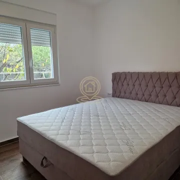 Spavaća soba sa bračnim krevetom i prozorom koji gleda na dvorište. - image 4