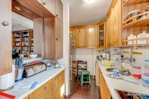 Compact kitchen with wooden cabinetry, a sink, and a countertop. - image 8