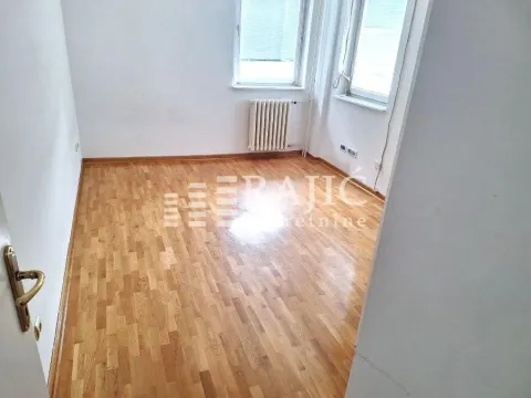 Prazna soba sa drvenim parketom i belim zidovima. - image 11