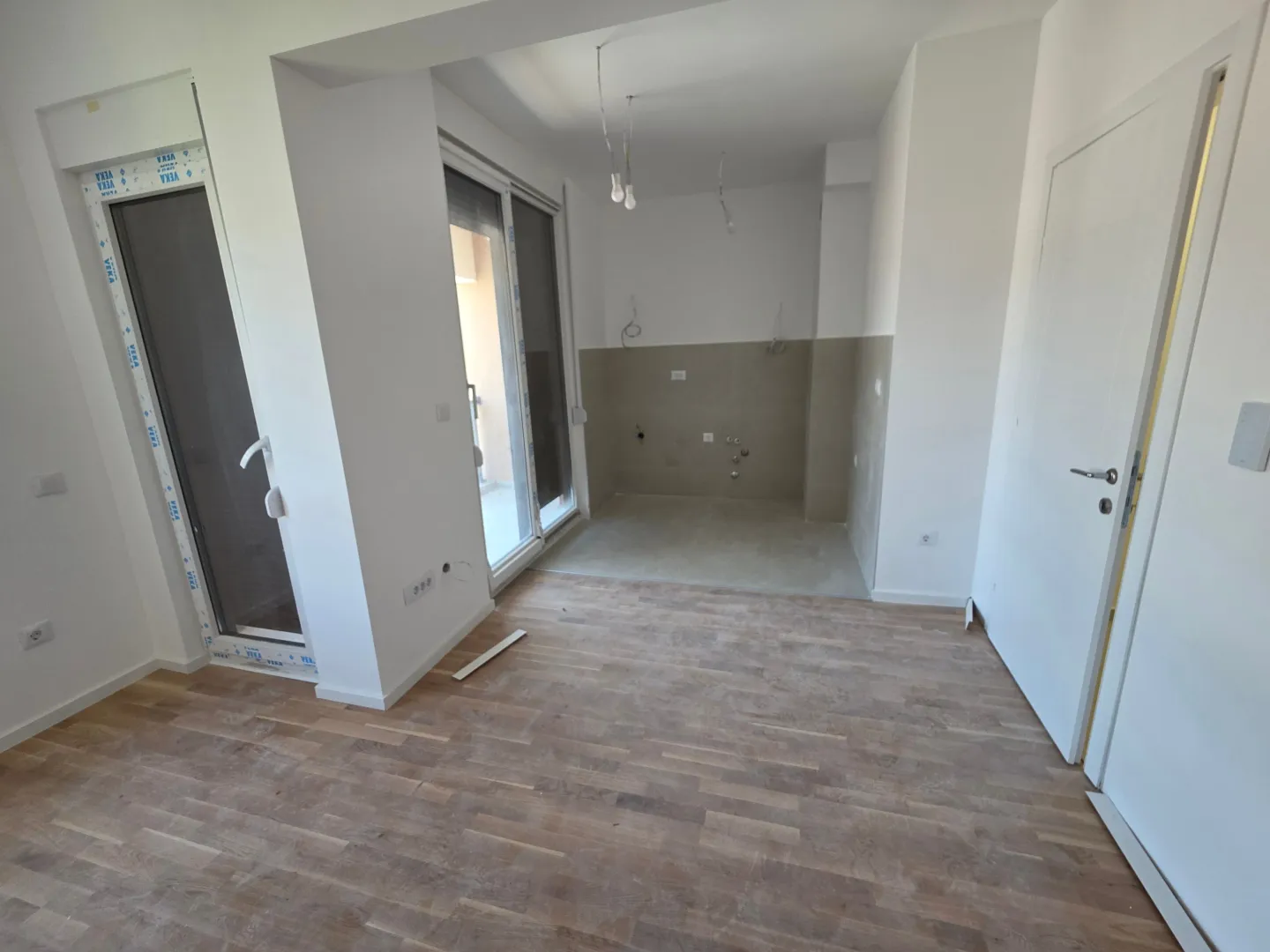 Empty kitchen space in a new construction with hardwood flooring.