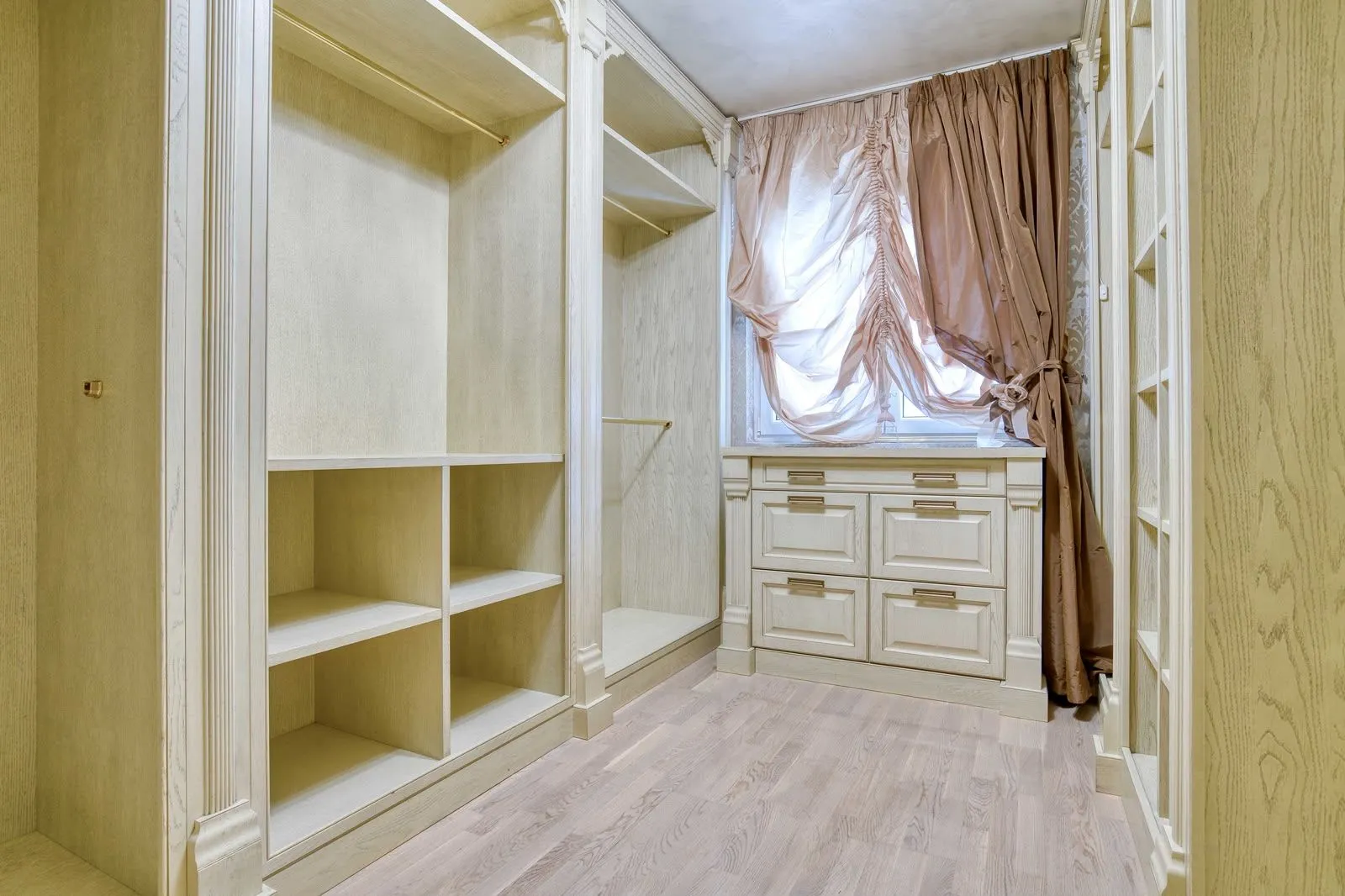 Walk-in closet with built-in wardrobes and a window.