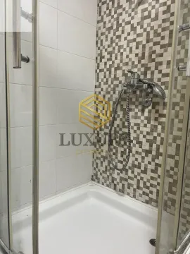 Small shower cabin with mosaic tiles and a faucet. - image 3