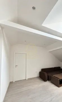 Dnevna soba sa kosim plafonom i braon garniturom. - image 8