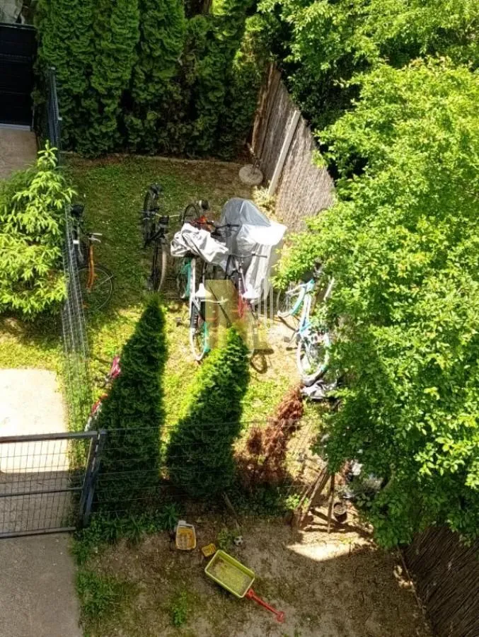 High-angle view of a green courtyard with parked bicycles.