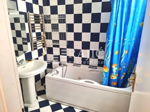 Kupatilo sa kadom, umivaonikom i crno-belim pločicama. - image 4