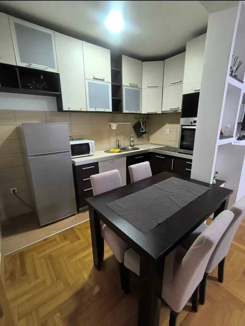 Kitchen with a dining area and wooden elements.